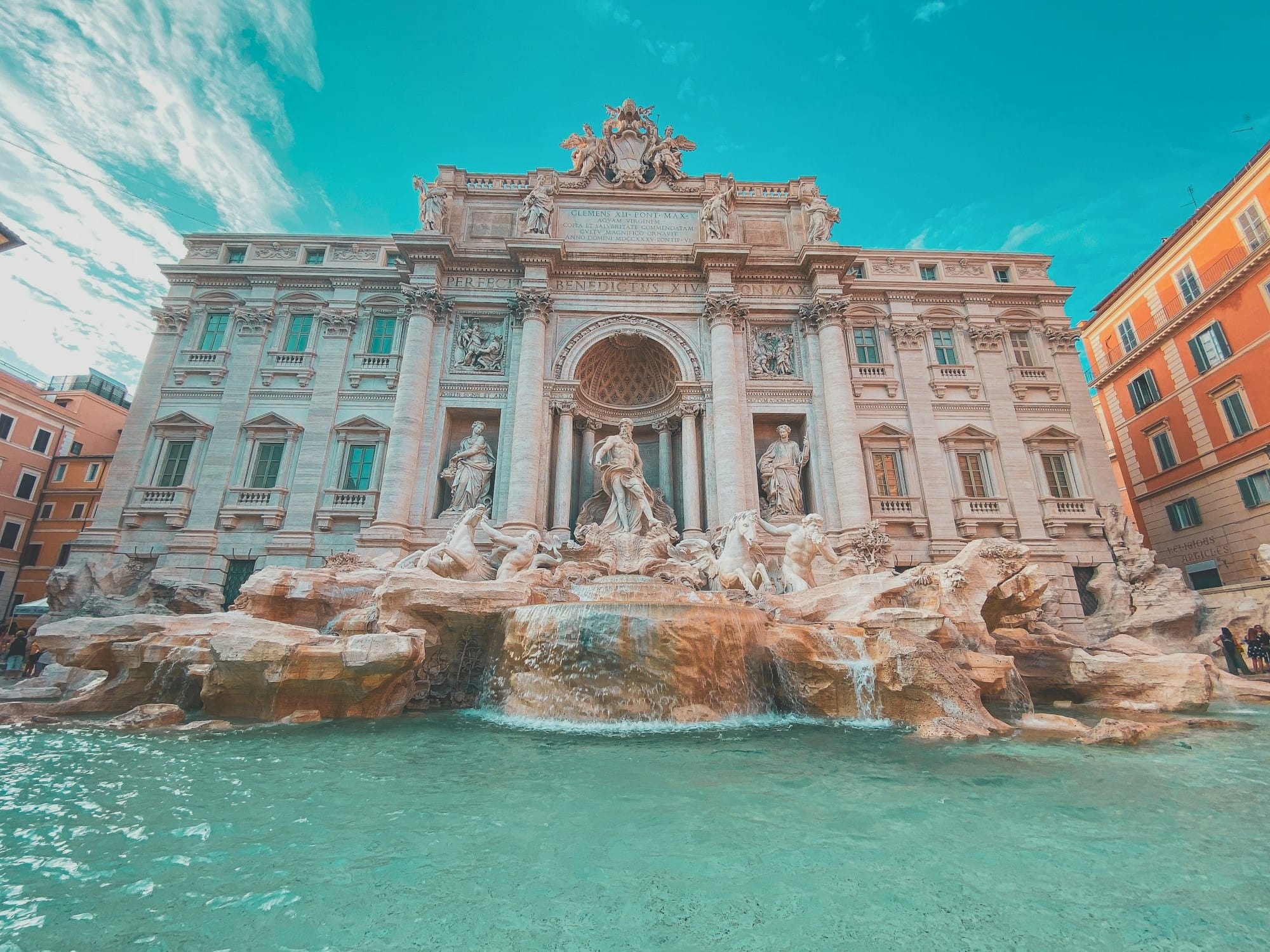 a large building with statues and a fountain in front of it with Trevi Fountain in the background